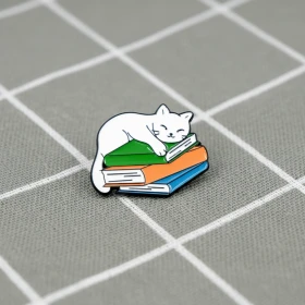 Pinarna.cz Bílá kočka spící na stohu knih