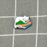 Pinarna.cz Bílá kočka spící na stohu knih