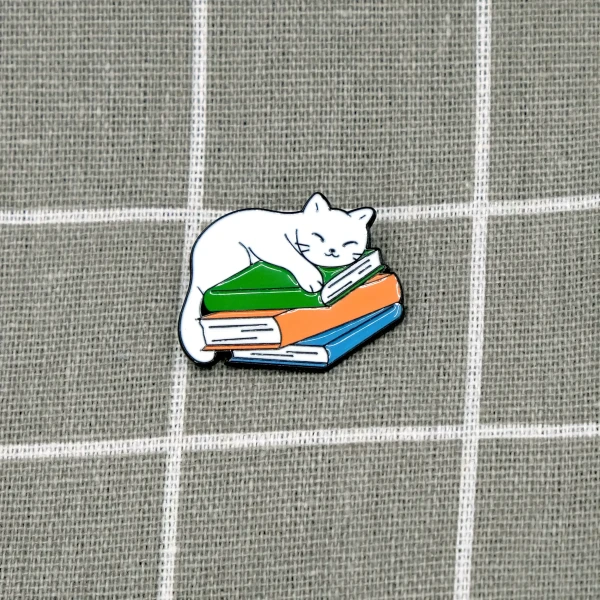 Pinarna.cz Bílá kočka spící na stohu knih