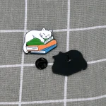 Pinarna.cz Bílá kočka spící na stohu knih