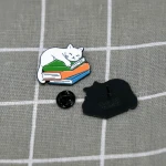 Pinarna.cz Bílá kočka spící na stohu knih